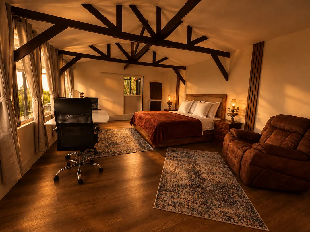 Suite Cóndor con cama King, escritorio y sillón reclinable bajo vigas de madera