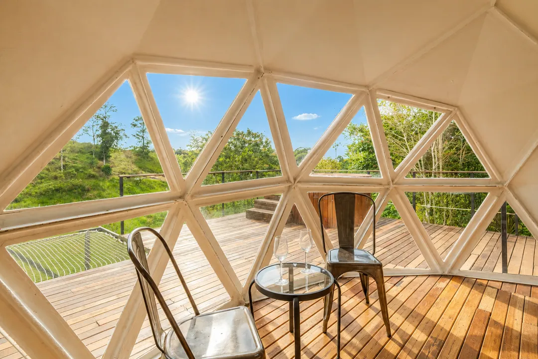 Ventanales triangulares del Domo Papiros con vista a la terraza y las montañas
