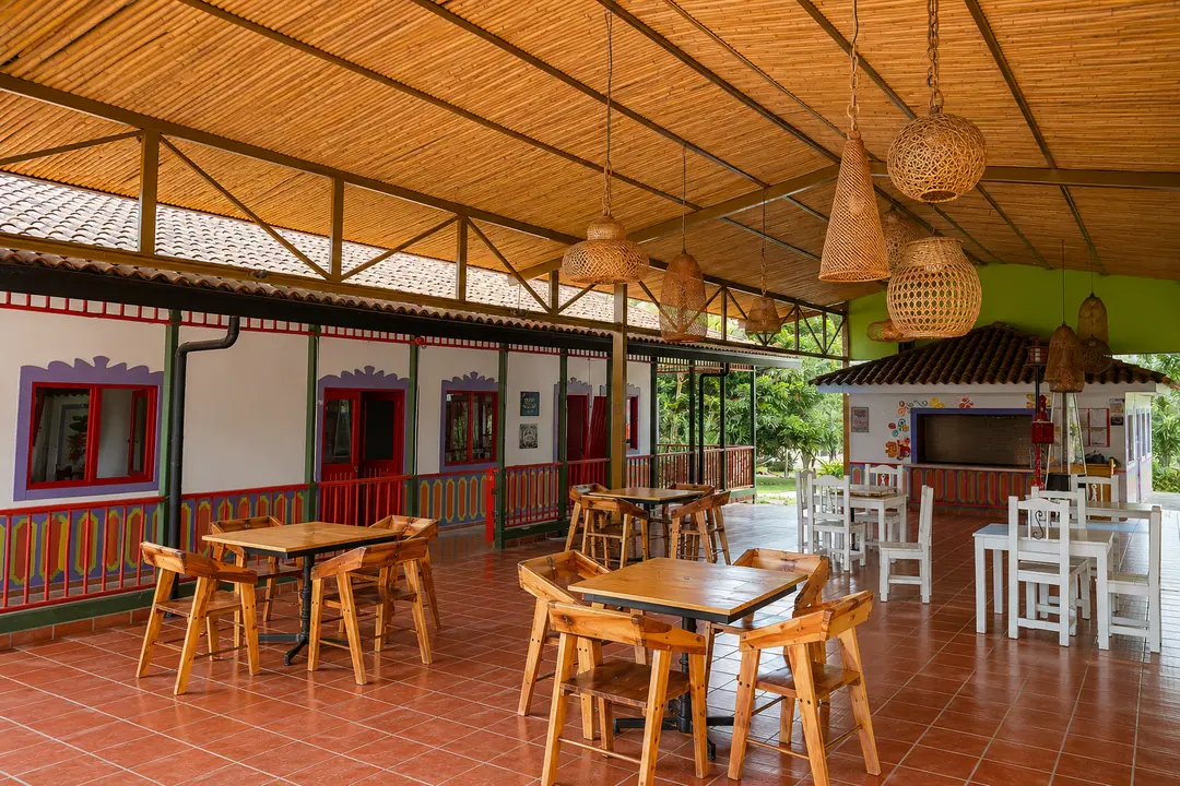 Zona social cubierta con mesas de madera y techo de guadua, donde abrirá el restaurante del hotel