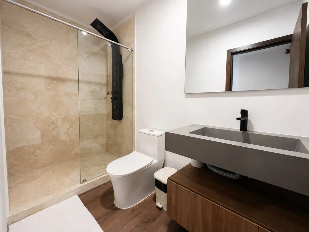 Baño de la Suite Aullador con ducha de vidrio y lavamanos de concreto