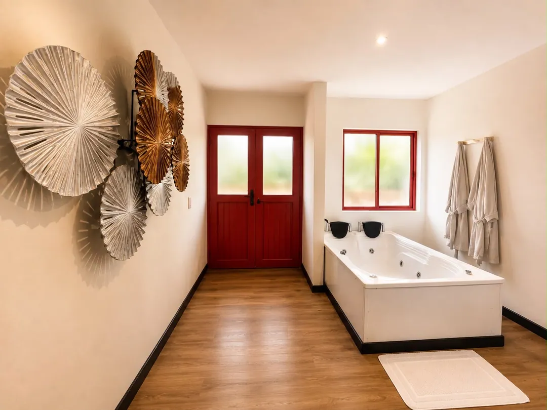 Jacuzzi con hidromasaje y batas frente a la puerta roja de la Suite Barranquero