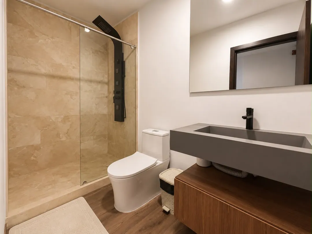 Baño de la Suite Colibrí con ducha de vidrio y lavamanos de concreto