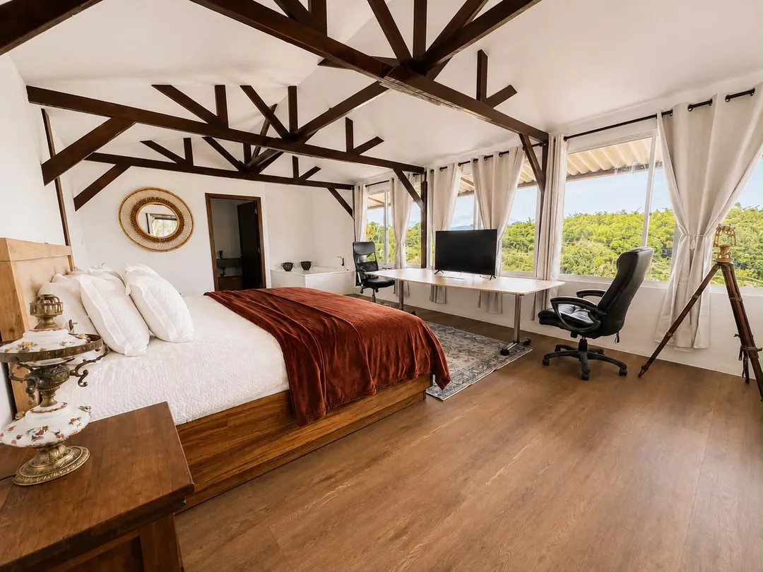Dormitorio de la Suite Cóndor con cama King y escritorio junto a los ventanales